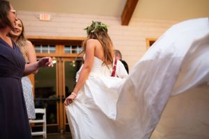 The bride's white dress flows gracefully as she dances at the reception.