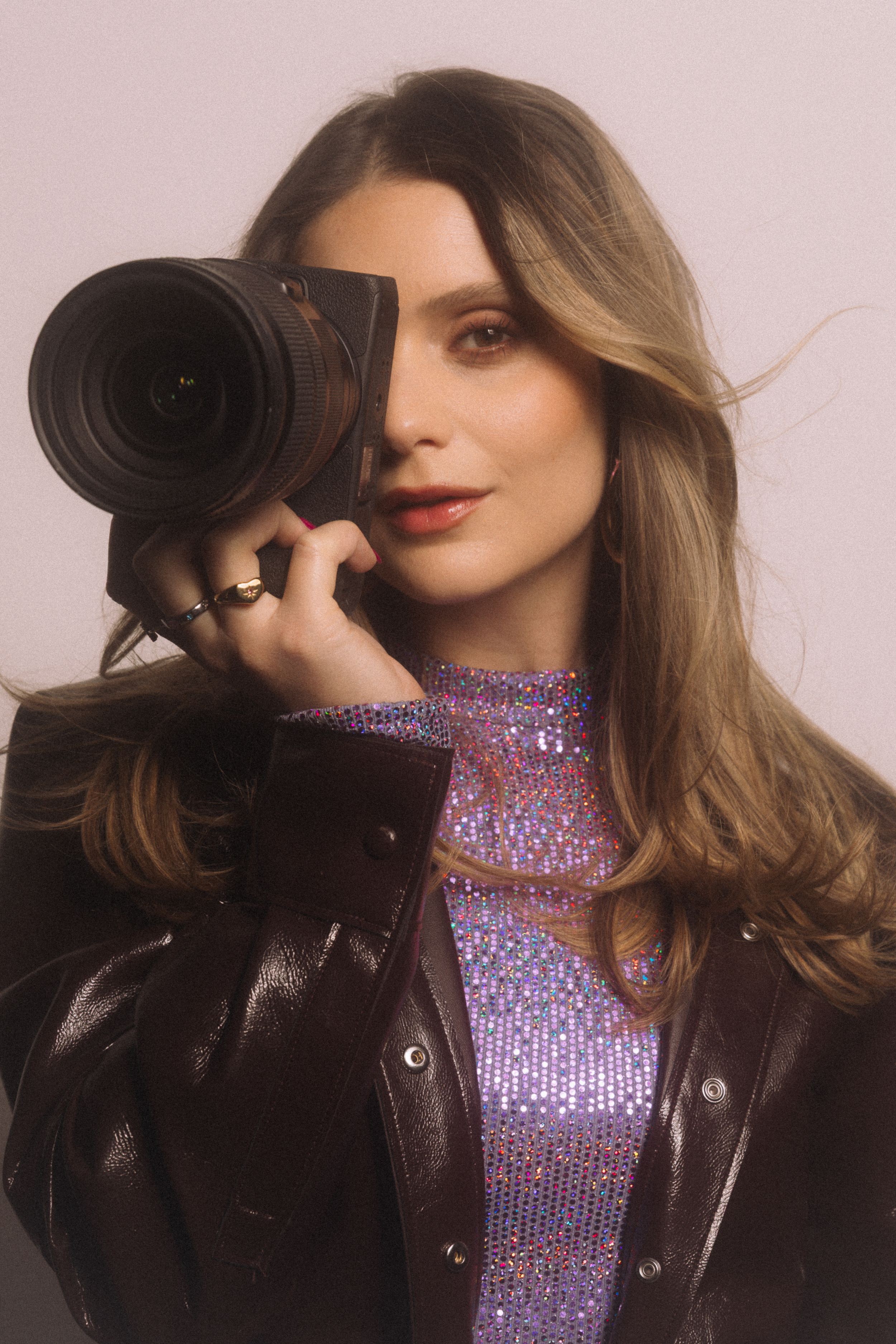 Sydney branding photographer wearing a vibrant red coat  capturing a professional headshot for a coach to build