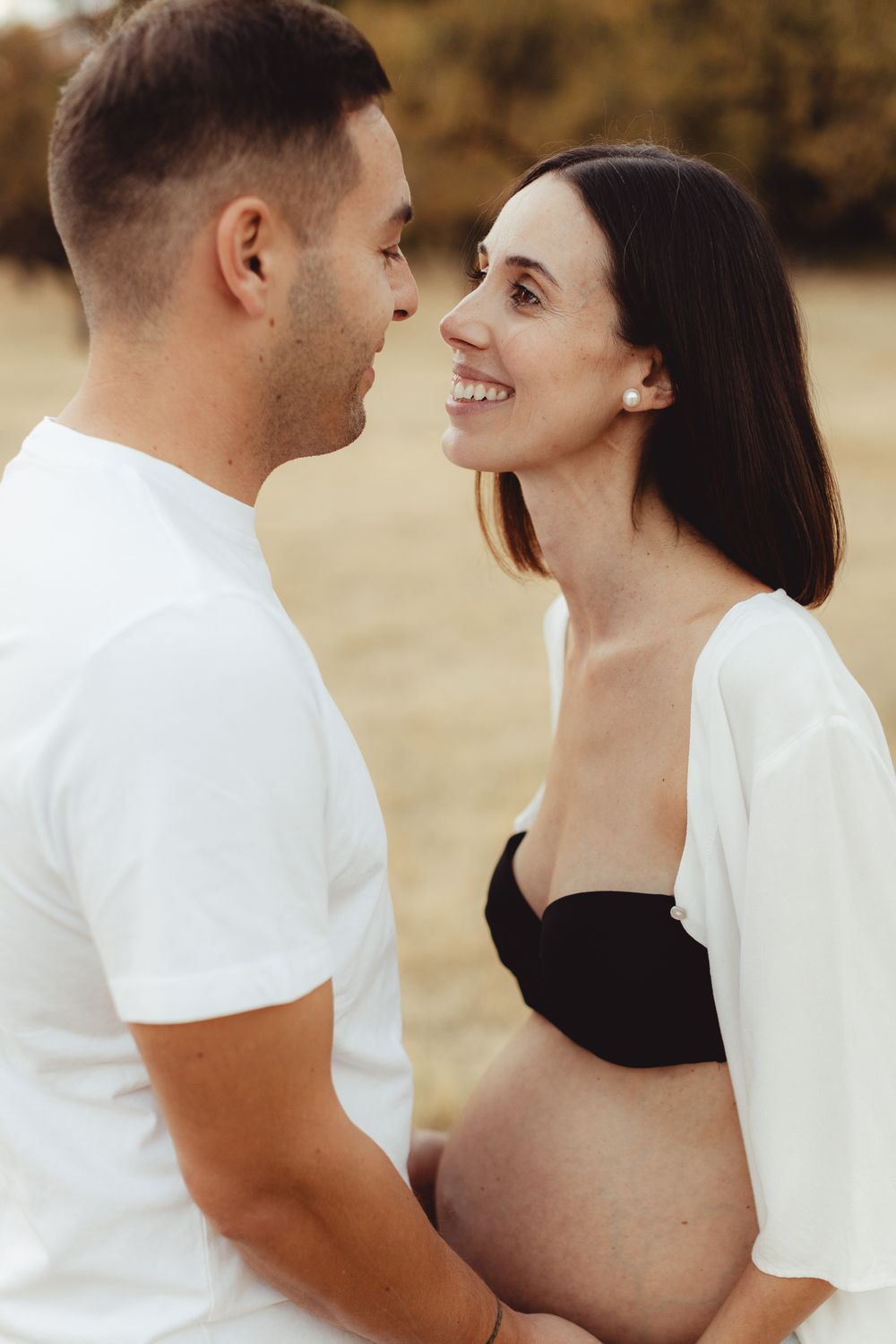 A romantic couple in white outfits share intimate moments in a series of sepia-toned photos.