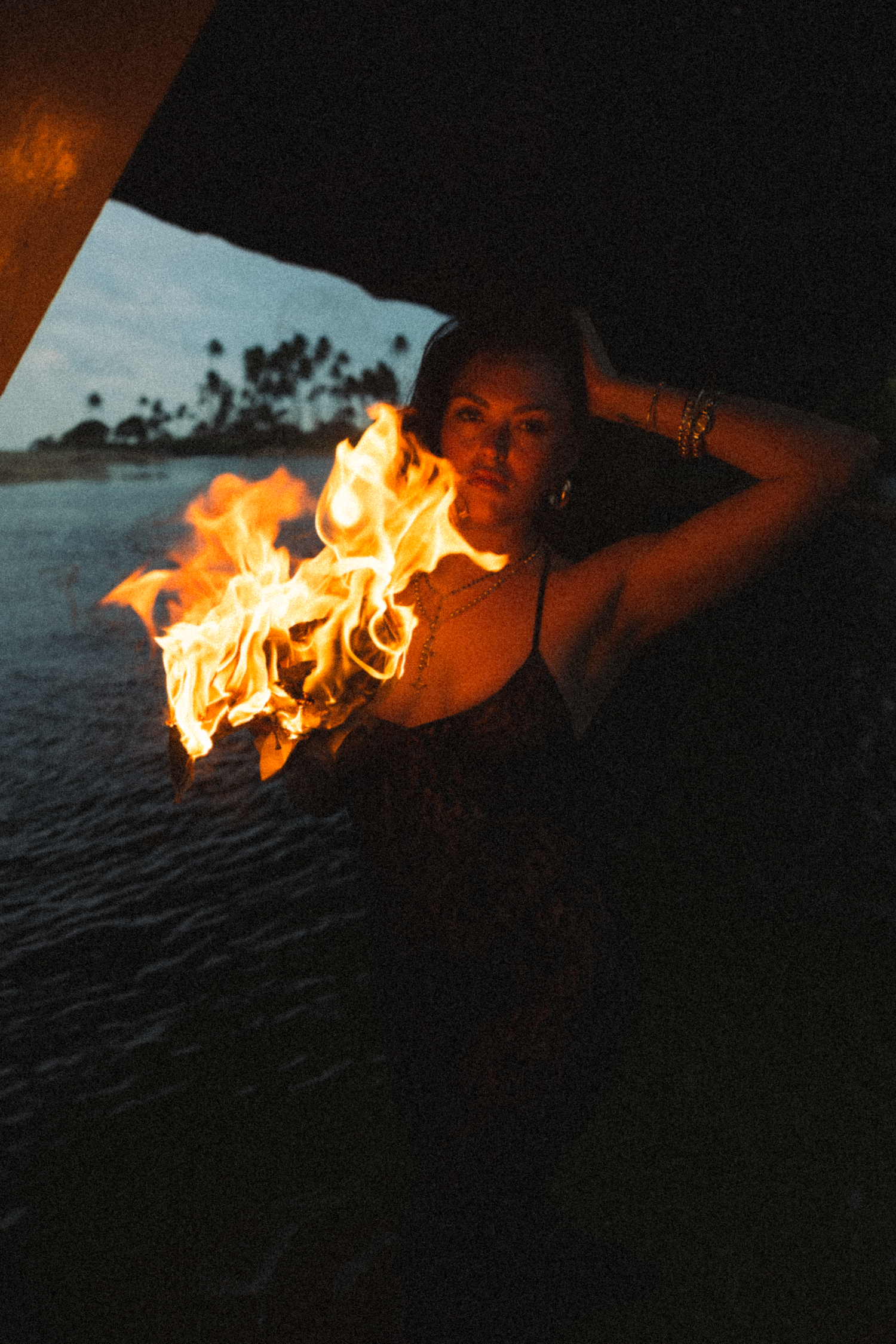 Trail of flames dancing along dark beach at night.