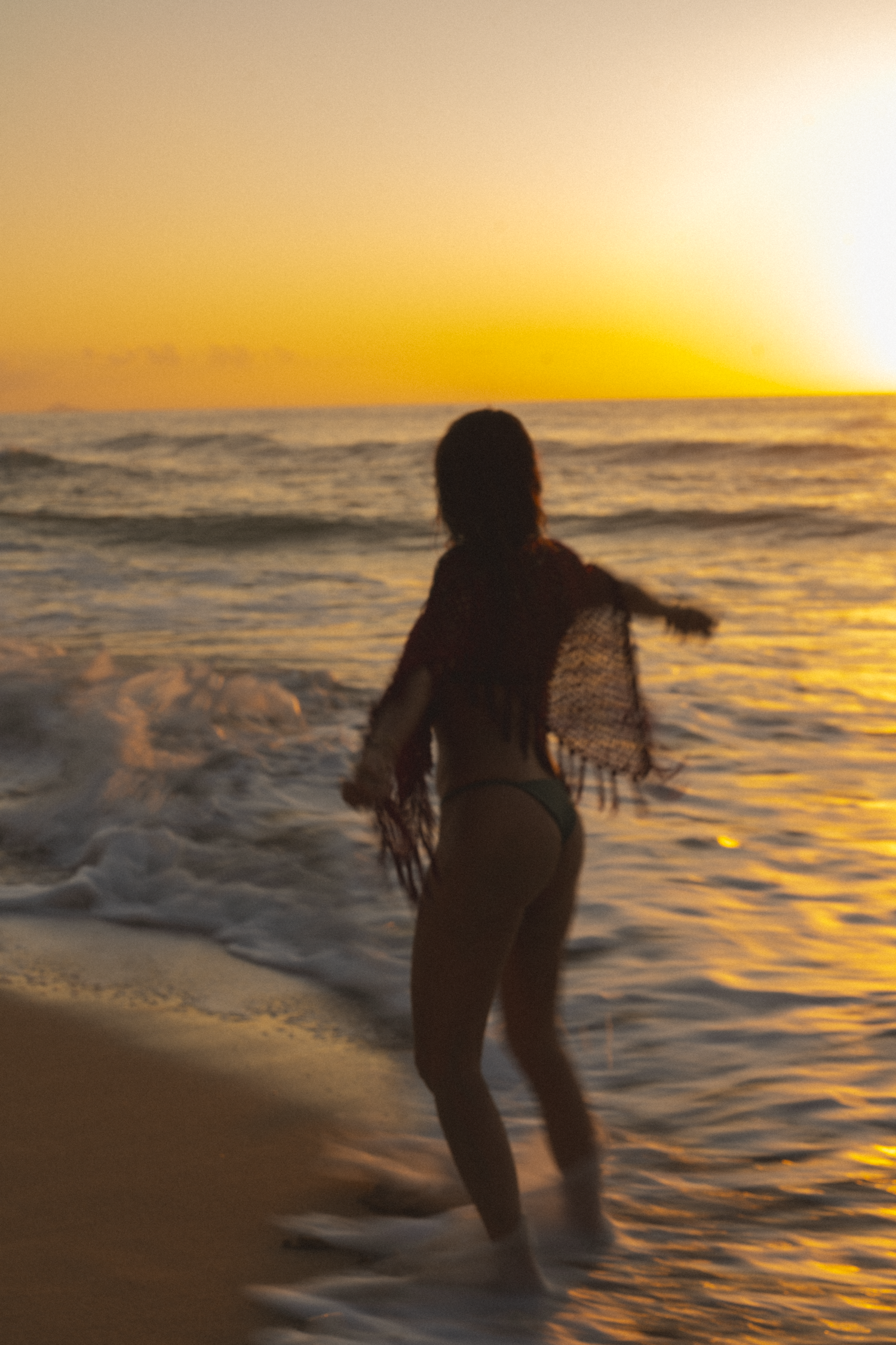 women running around on a beach on kauai during a sunset