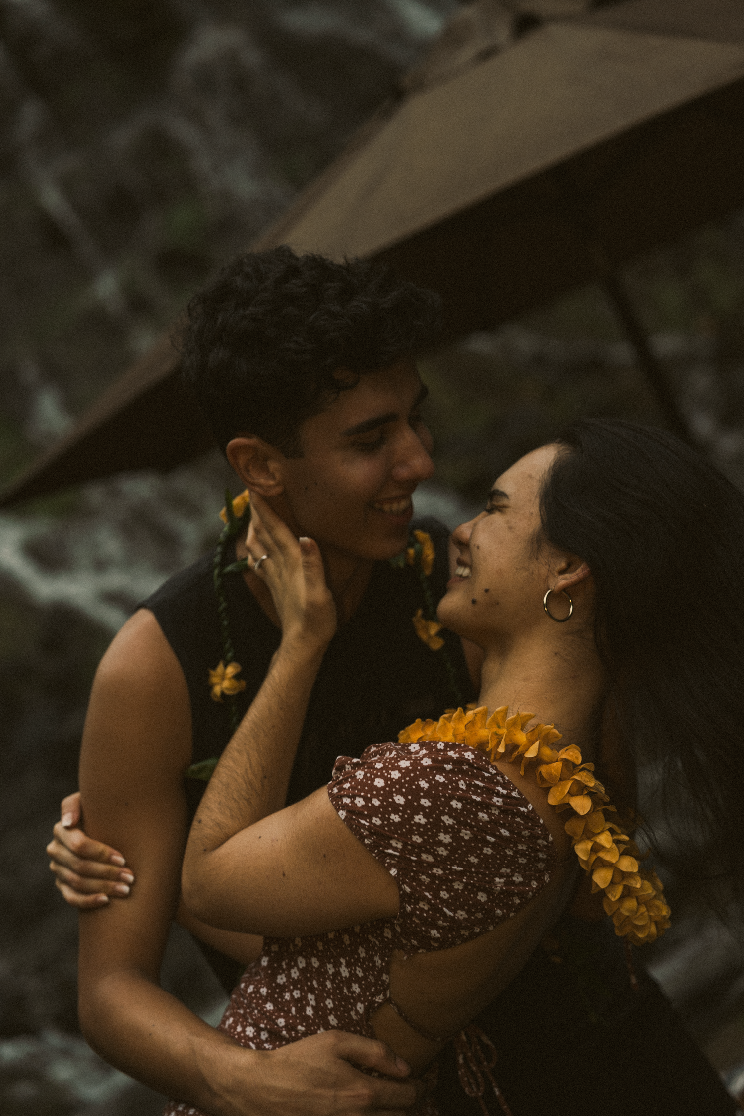 Romantic portrait series showing an intimate moment with yellow flowers against a moody dark background.