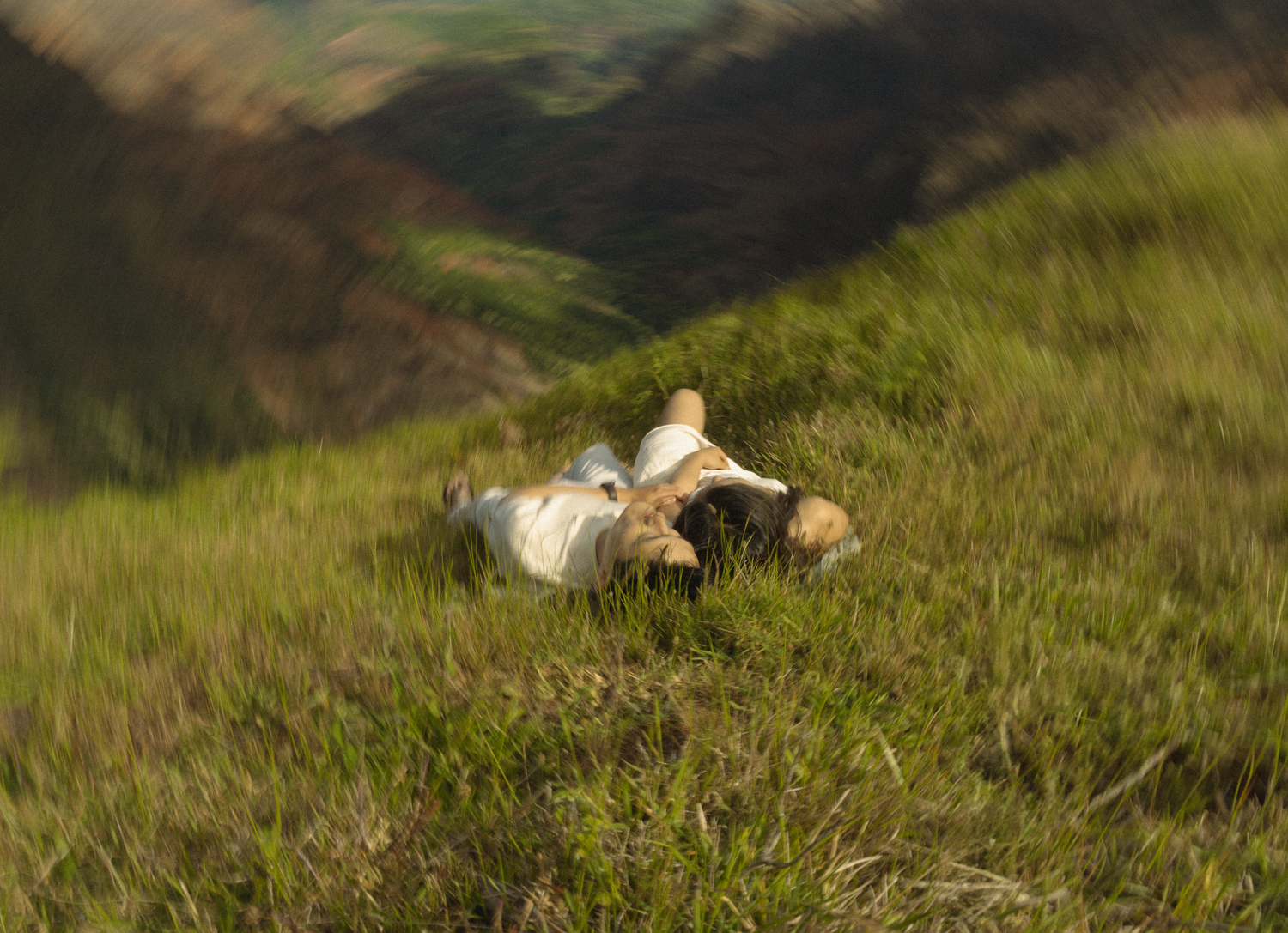 People relaxing on green grass against blurred natural background.