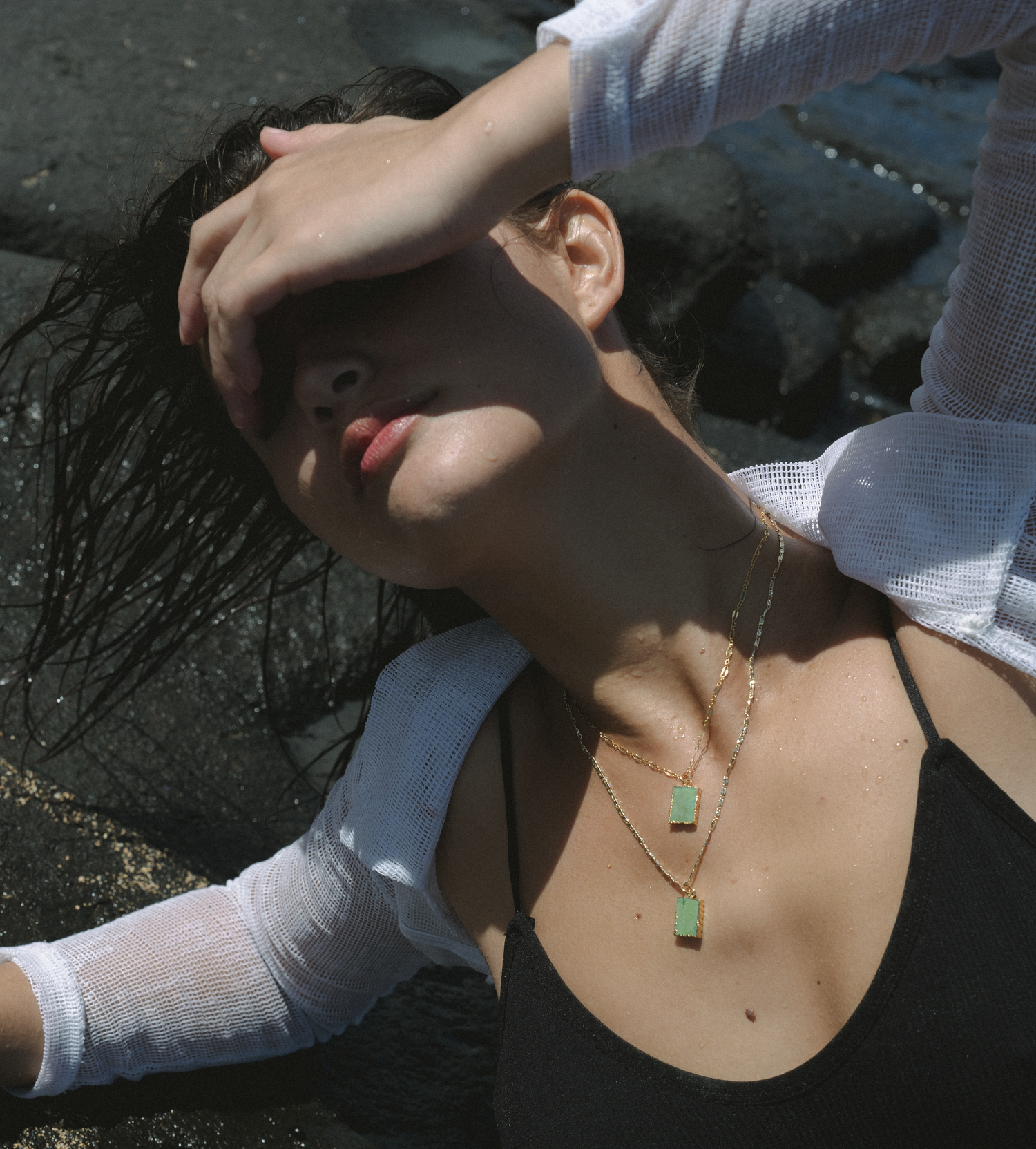 Candid moment showing delicate jade pendant necklace in natural lighting.