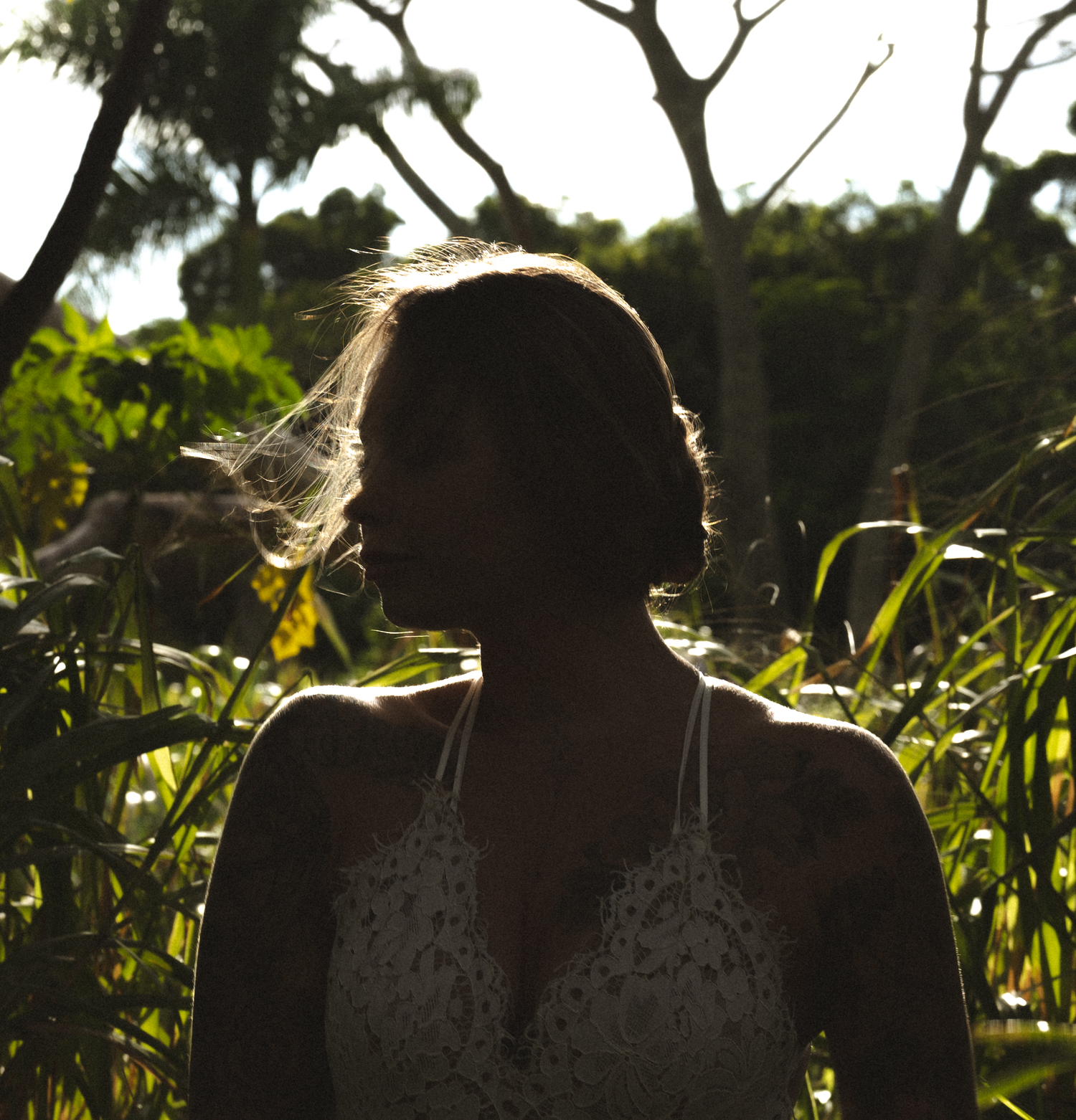 Backlit figures in white dress creating dreamy silhouettes at sunset.