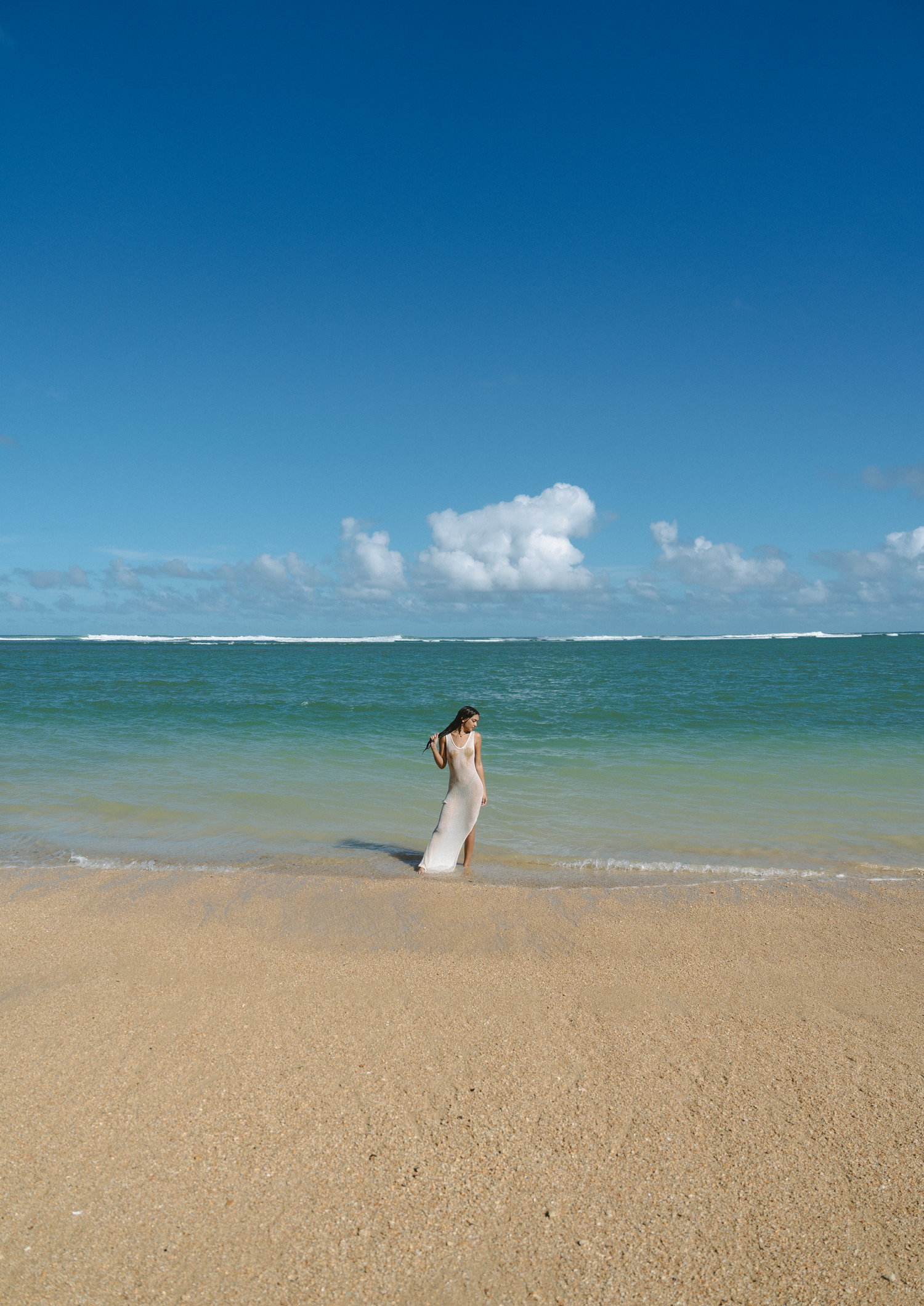 Serene beach landscape with turquoise water and pristine sand under bright blue sky.
