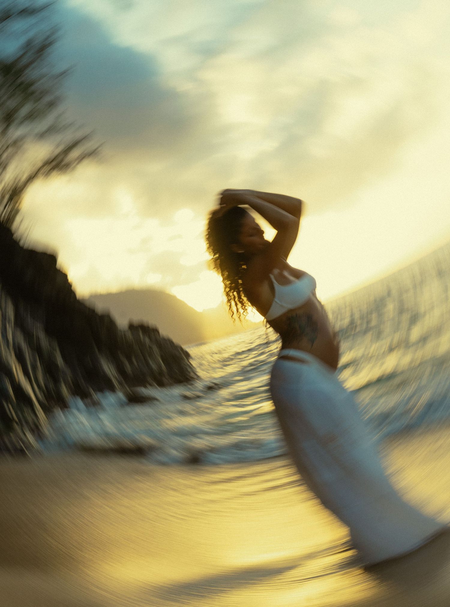 Abstract motion blur of palm trees and sky at sunset creating a dreamy tropical beach scene in golden light.