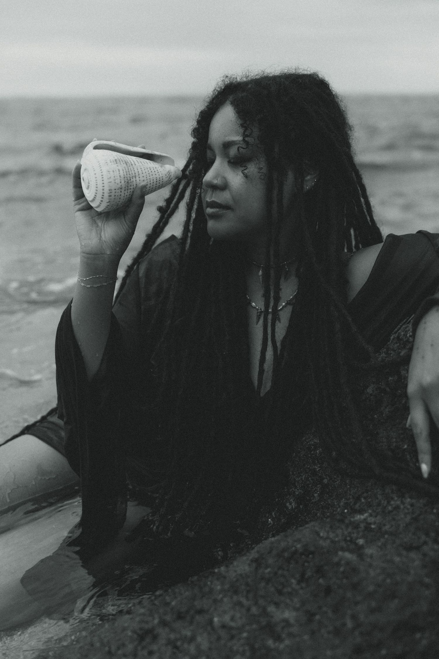 A black and white photo series shows someone drinking from a can while lying on a beach.
