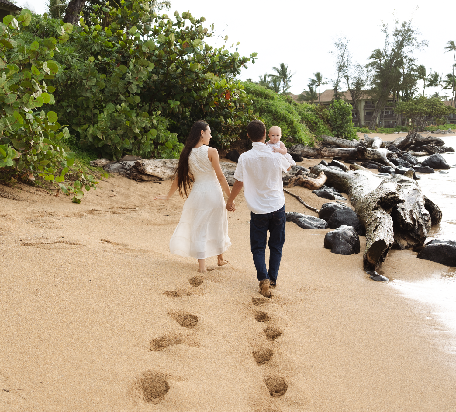 A familly taking a walk on the beach and holding hands during the early morning light.