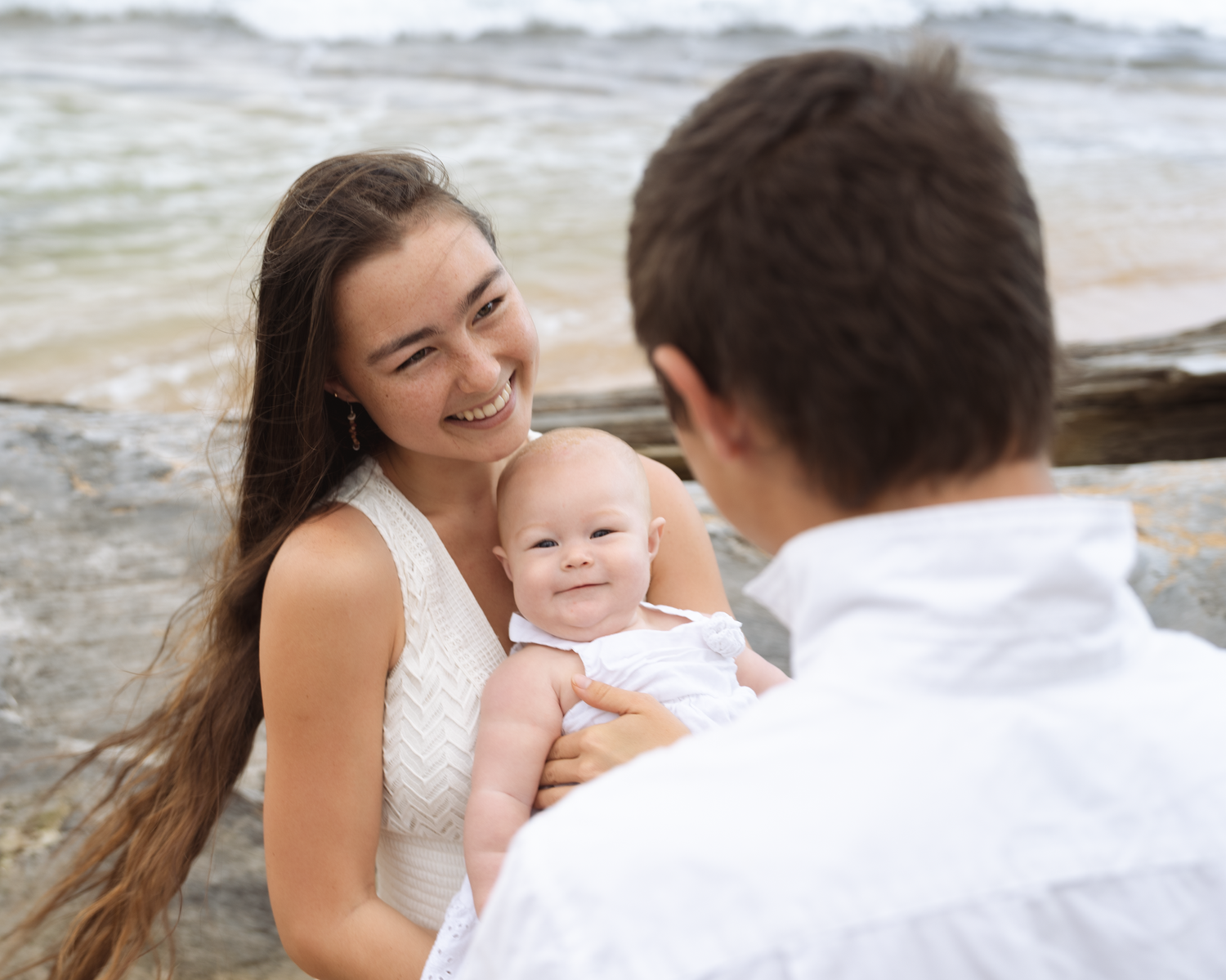young family, laughing and enjoying every moment with each other on a beach