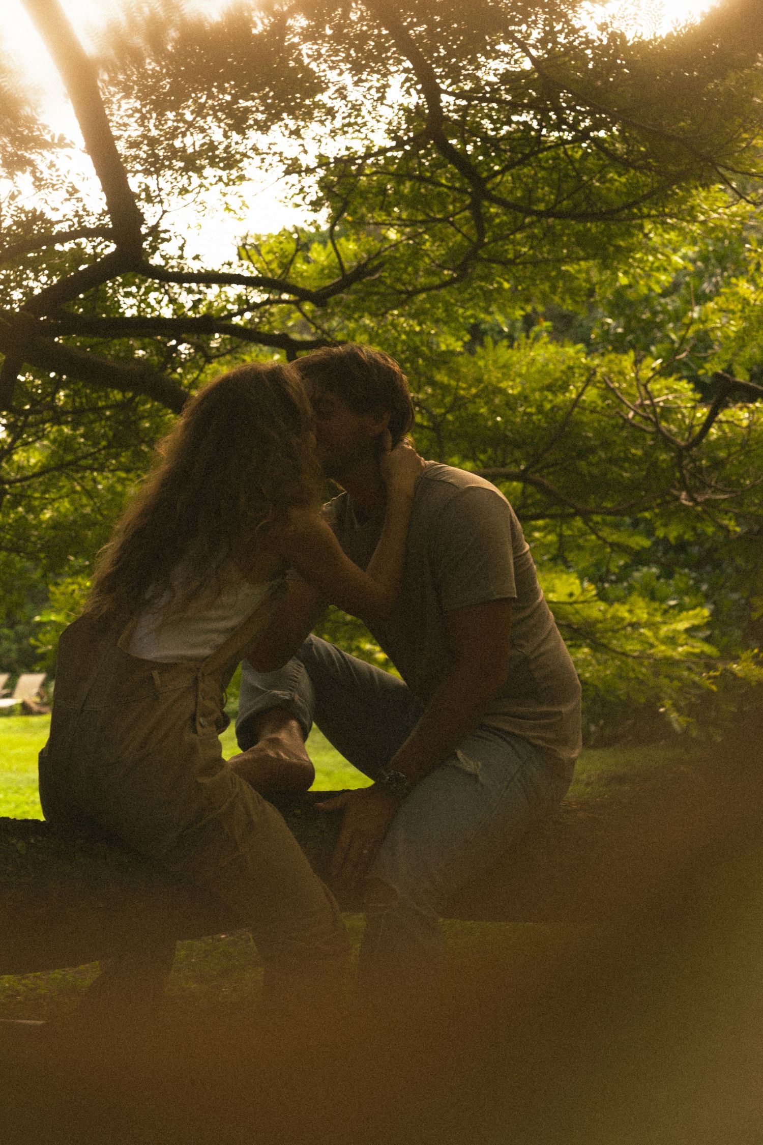 Silhouettes of people against golden sunlight through tree branches.