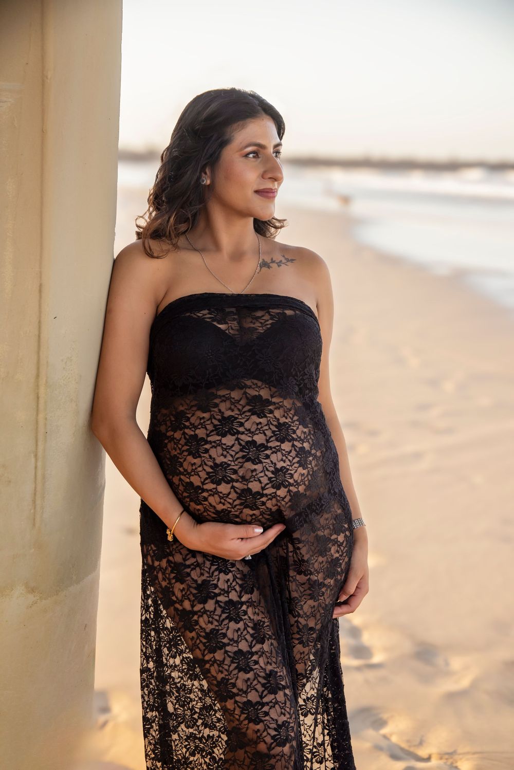 Soft Gorgeous Maternity Photography at the Spit Gold Coast pregnant woman in a black lace dress