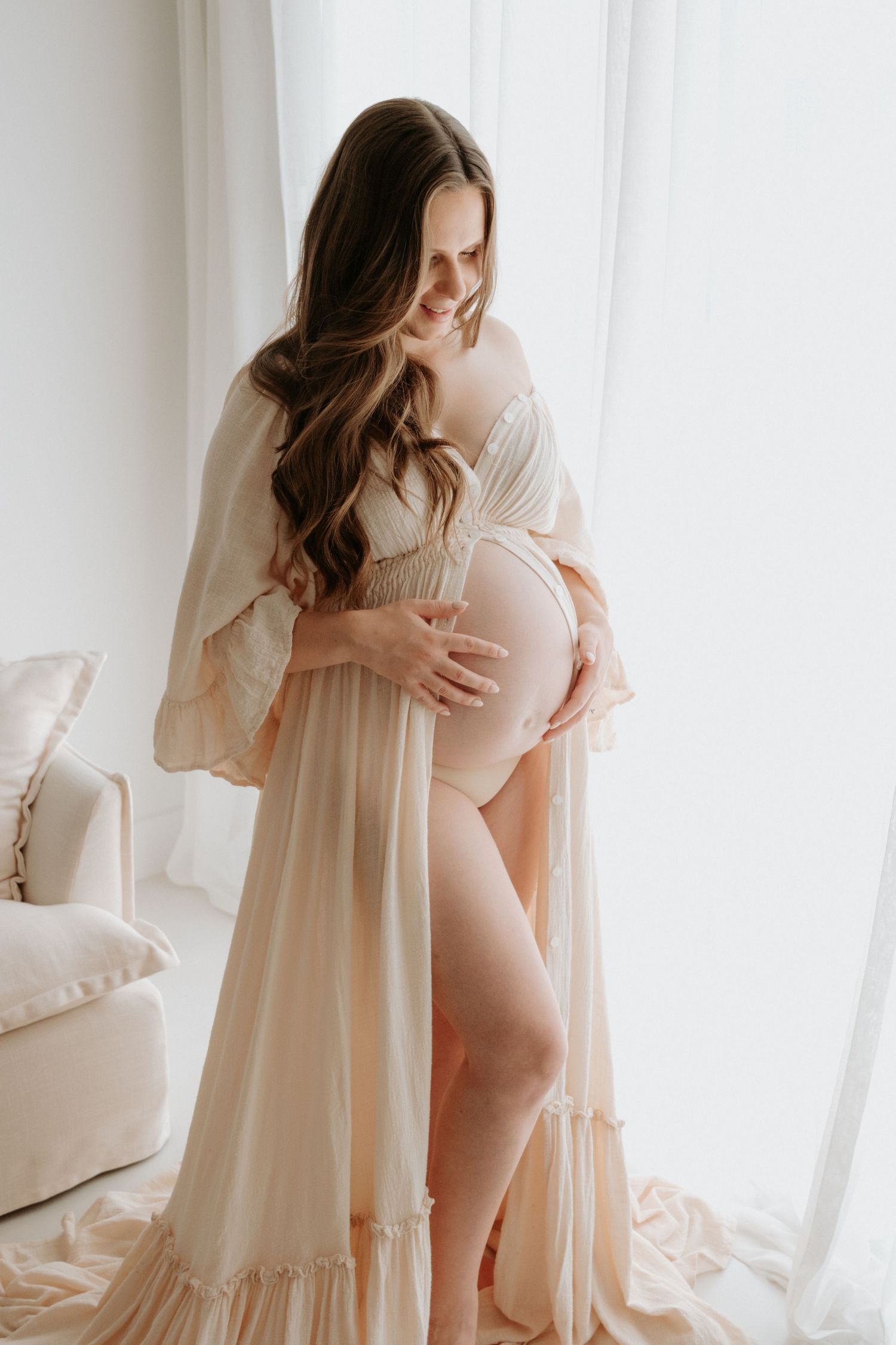 Ethereal maternity photography with flowing sheer dress in bright natural light. Captured in a natural light studio in the blue mountains