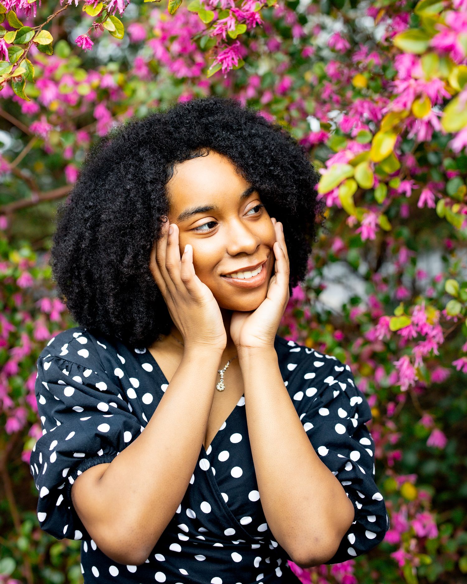 Artistic portrait against white columns featuring black outfit and expressive pose.