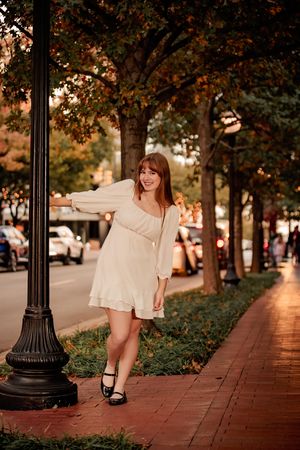 A collection of outdoor portraits on a brick sidewalk at sunset with autumn trees and lamp posts in the background.