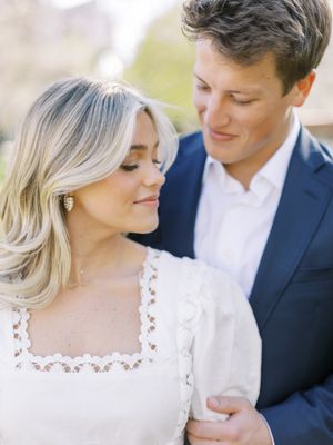 Couple in elegant attire sharing an intimate moment outdoors.