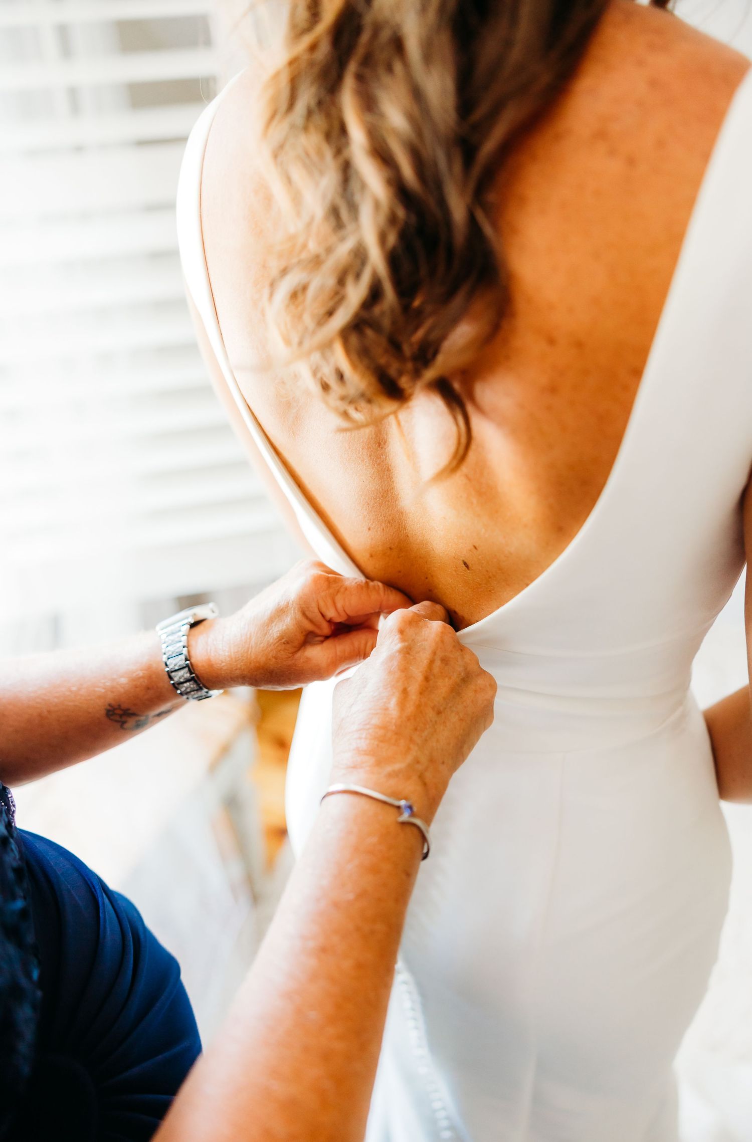Close-up sequence showing someone putting on a delicate silver bracelet around their wrist.