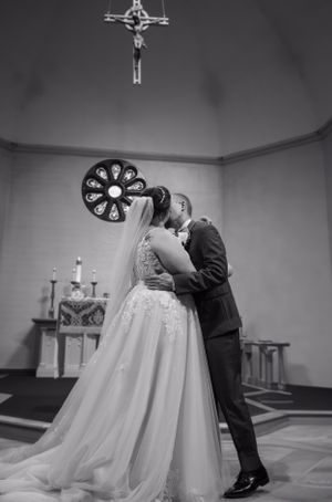A tender ballroom dancing moment captured in black and white during a wedding ceremony.