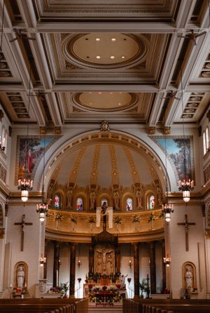 Ornate church interior with golden dome ceiling, crosses, and religious artwork.