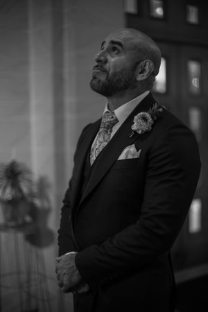 Emotional black and white portrait of groomsmen during wedding ceremony.