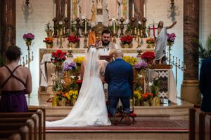 Church wedding ceremony with vibrant floral decorations and traditional altar setting.