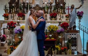 Wedding ceremony in an elegant church with floral arrangements and classic architecture.