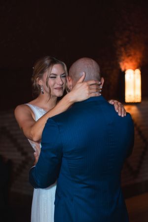 Romantic dance moment captured in warm lighting at wedding reception.
