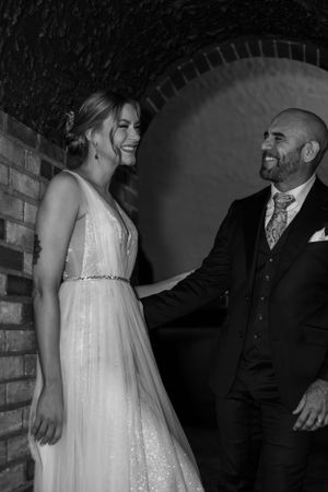 Black and white image of wedding couple sharing a dance in intimate lighting.