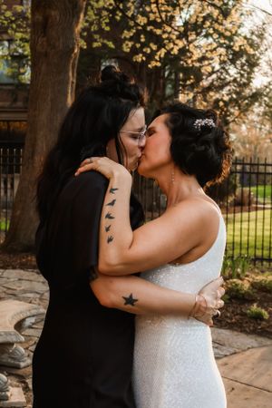 Intimate wedding portrait of couple sharing a romantic moment outdoors.
