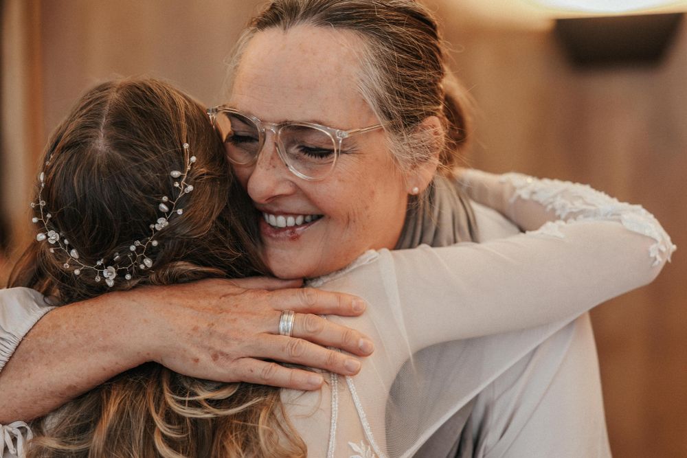Emotional wedding reception moments captured through a series of embraces.
