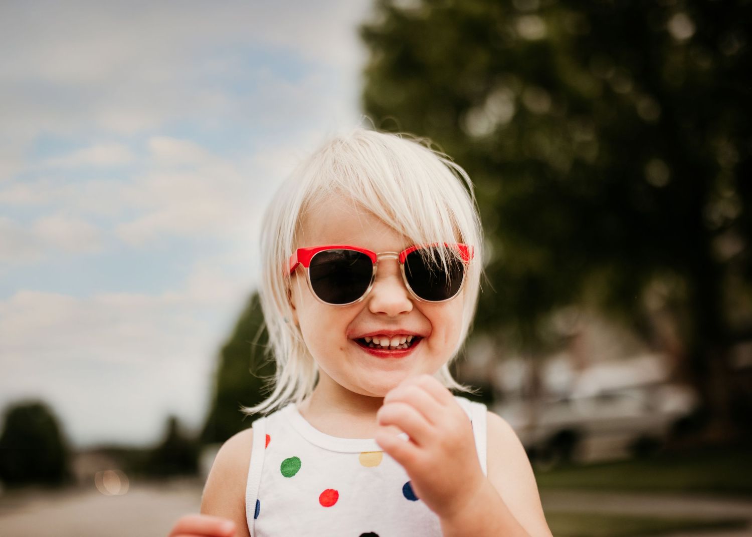 Fun image of happy girl wearing red sunglasses during the summer