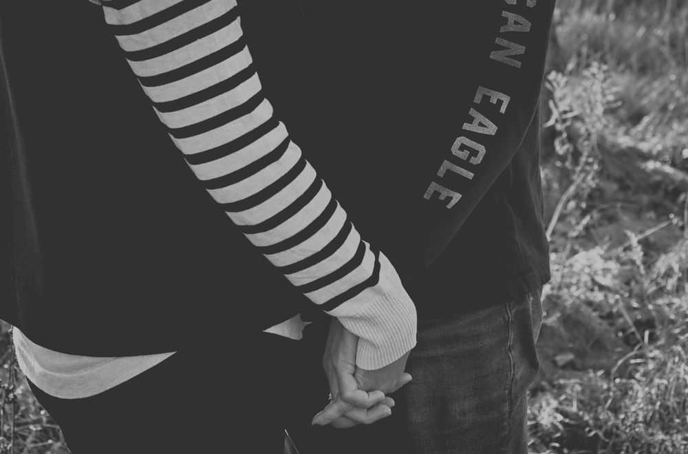 Couple holding hands in black and white.
