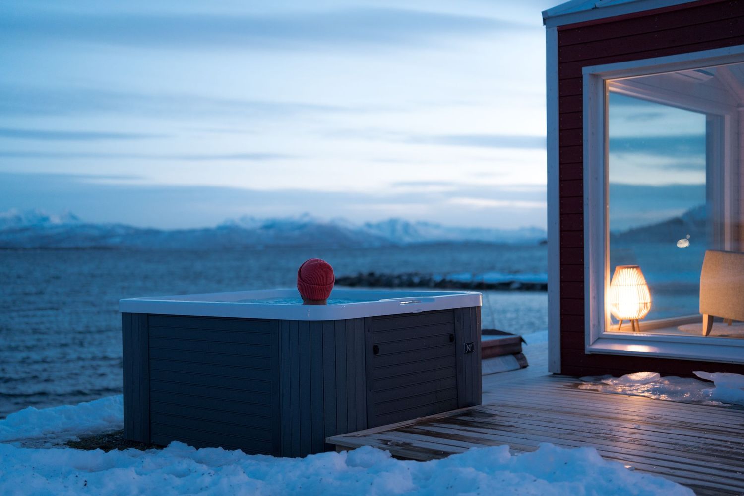 photo hôtel norvège avec un jacuzzi en bord de fjord pendant l'hiver