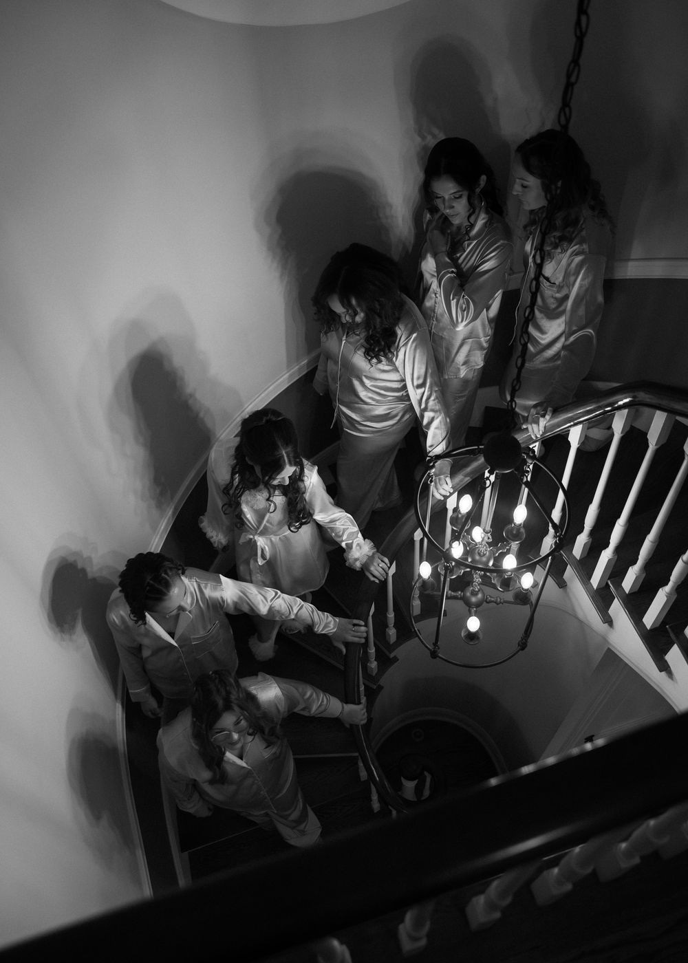 A sequence of black and white security camera images showing people walking down a staircase.