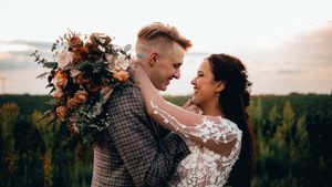 A romantic mountain wedding portrait featuring a beautiful floral bouquet at sunset.