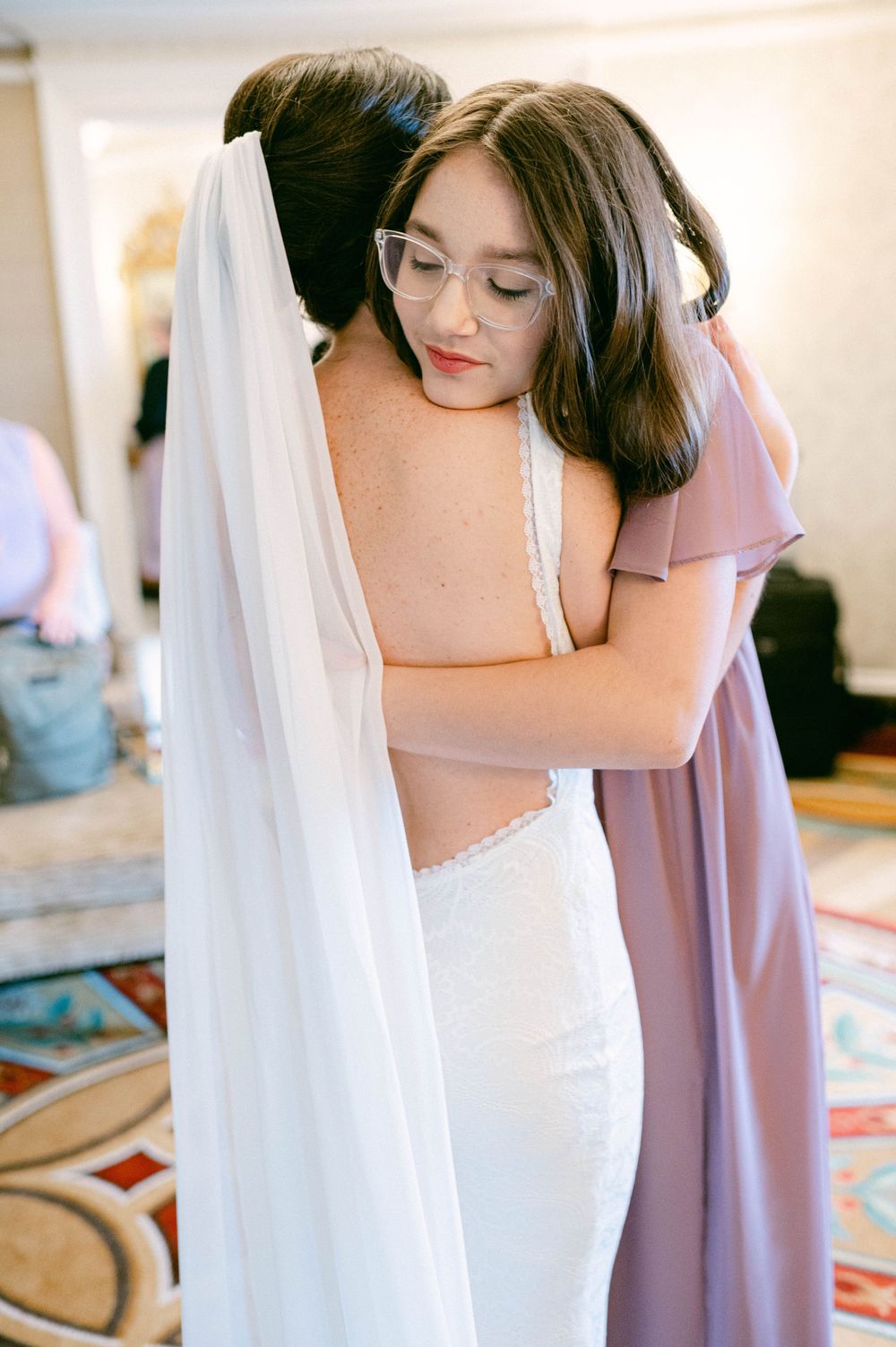 Two people embrace in an emotional moment during wedding preparations.