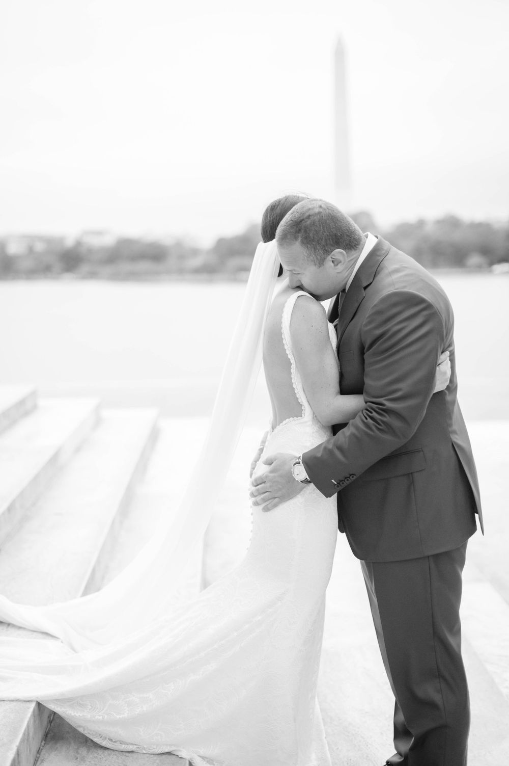 Black and white romantic wedding portrait with Washington Monument in distance.
