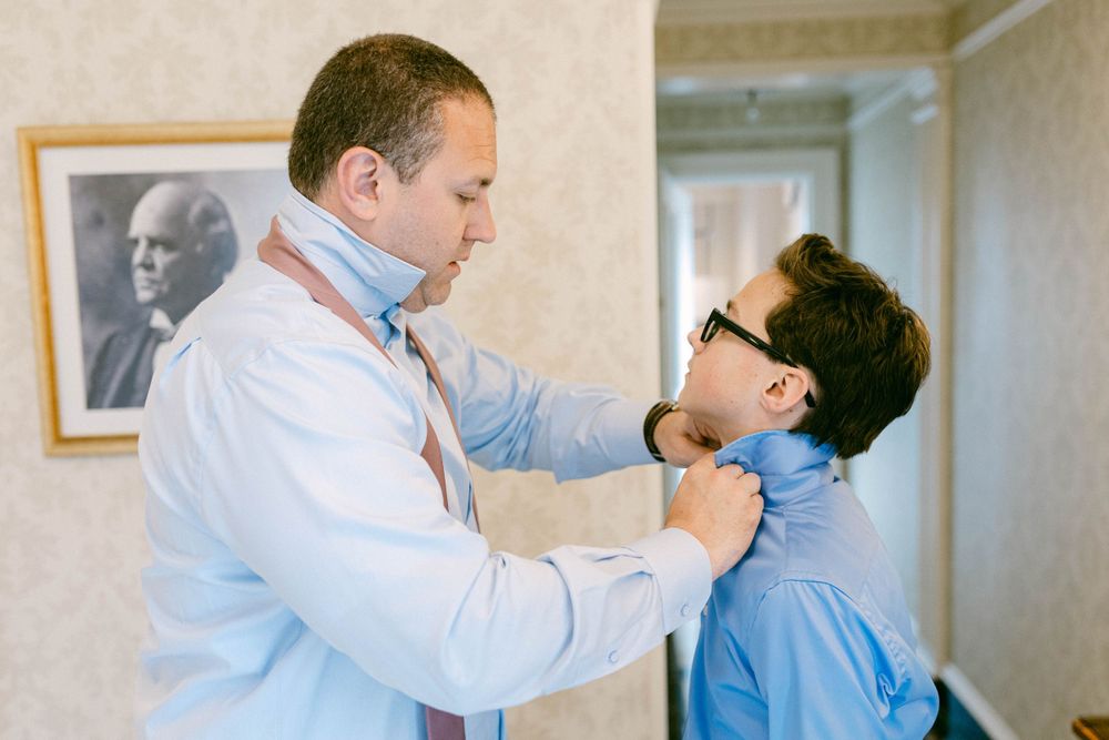 Wedding day preparation sequence showing formal attire adjustments.