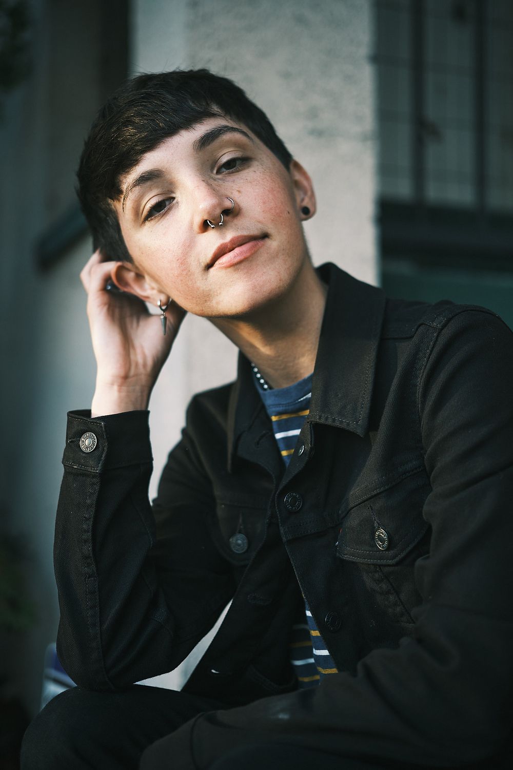 Casual portrait in striped shirt and dark jacket with natural lighting.