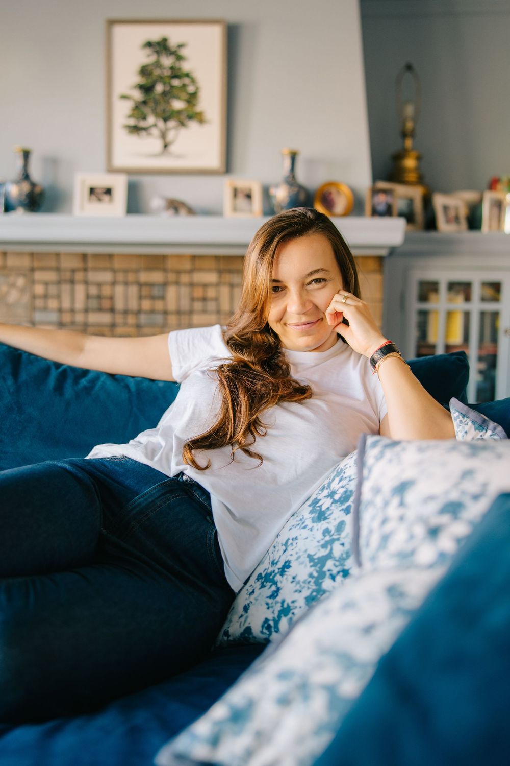 A series of four photos showing someone relaxing on a blue couch in a bright living room with natural lighting.