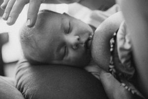 Black and white photo of a sleeping infant wrapped in soft blankets.