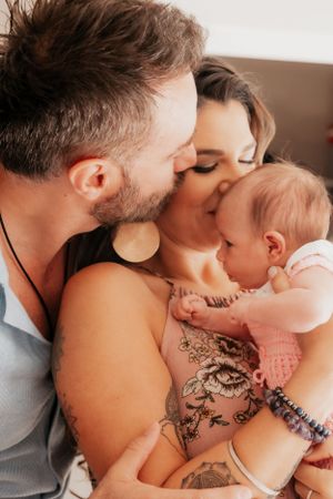 Intimate family moment captured while embracing on comfortable furniture.