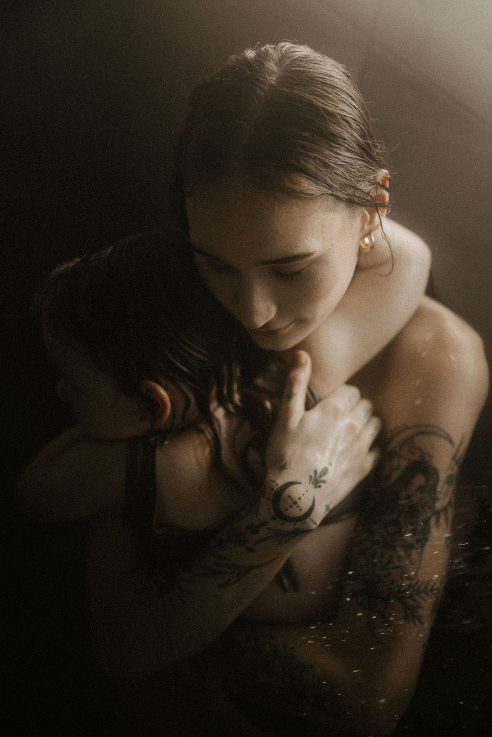 A dark and moody artistic portrait series showing a person with tattoos in shadowy lighting.