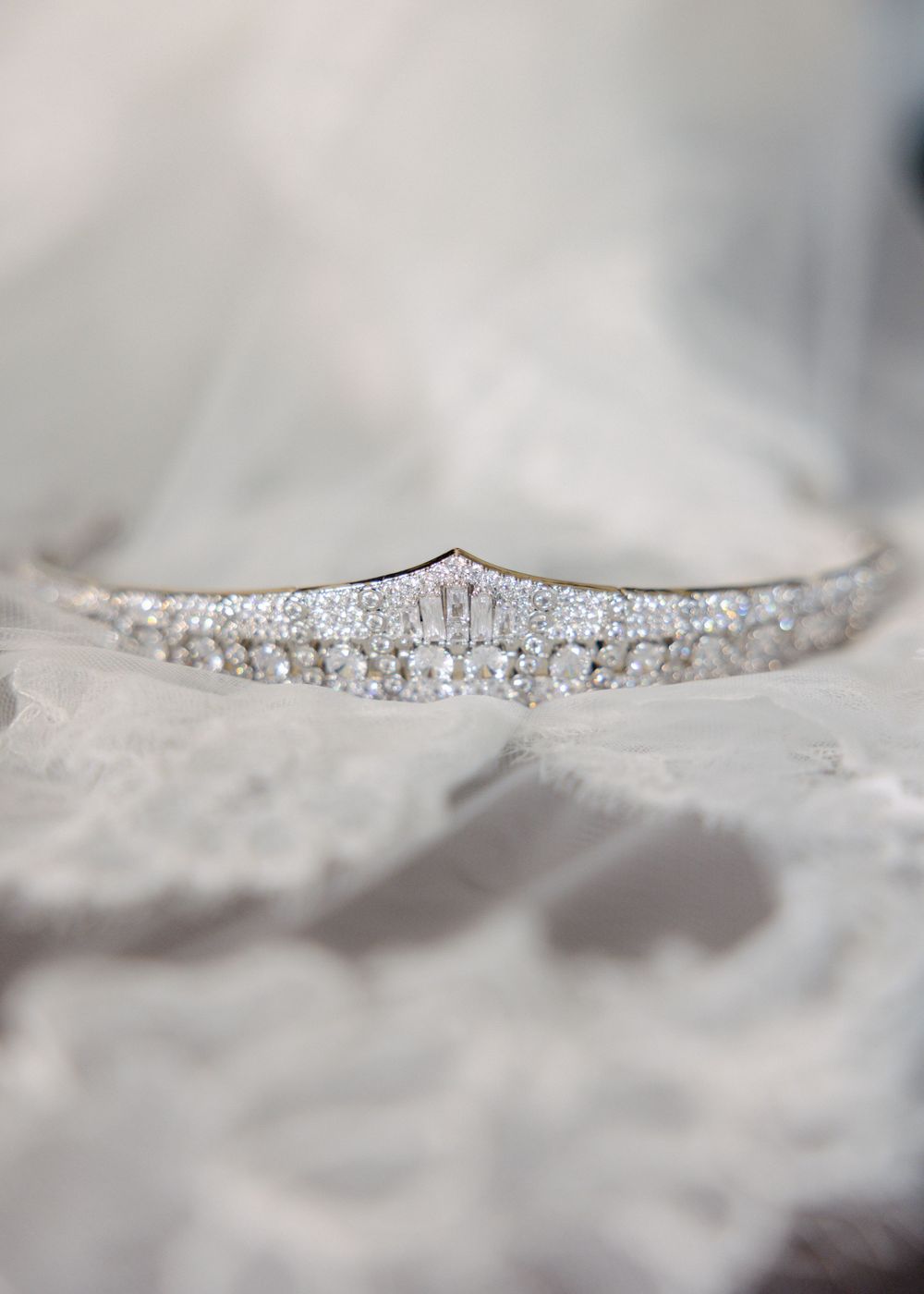 Close-up detail shot of delicate crystal beading and embellishments on white fabric with soft focus.