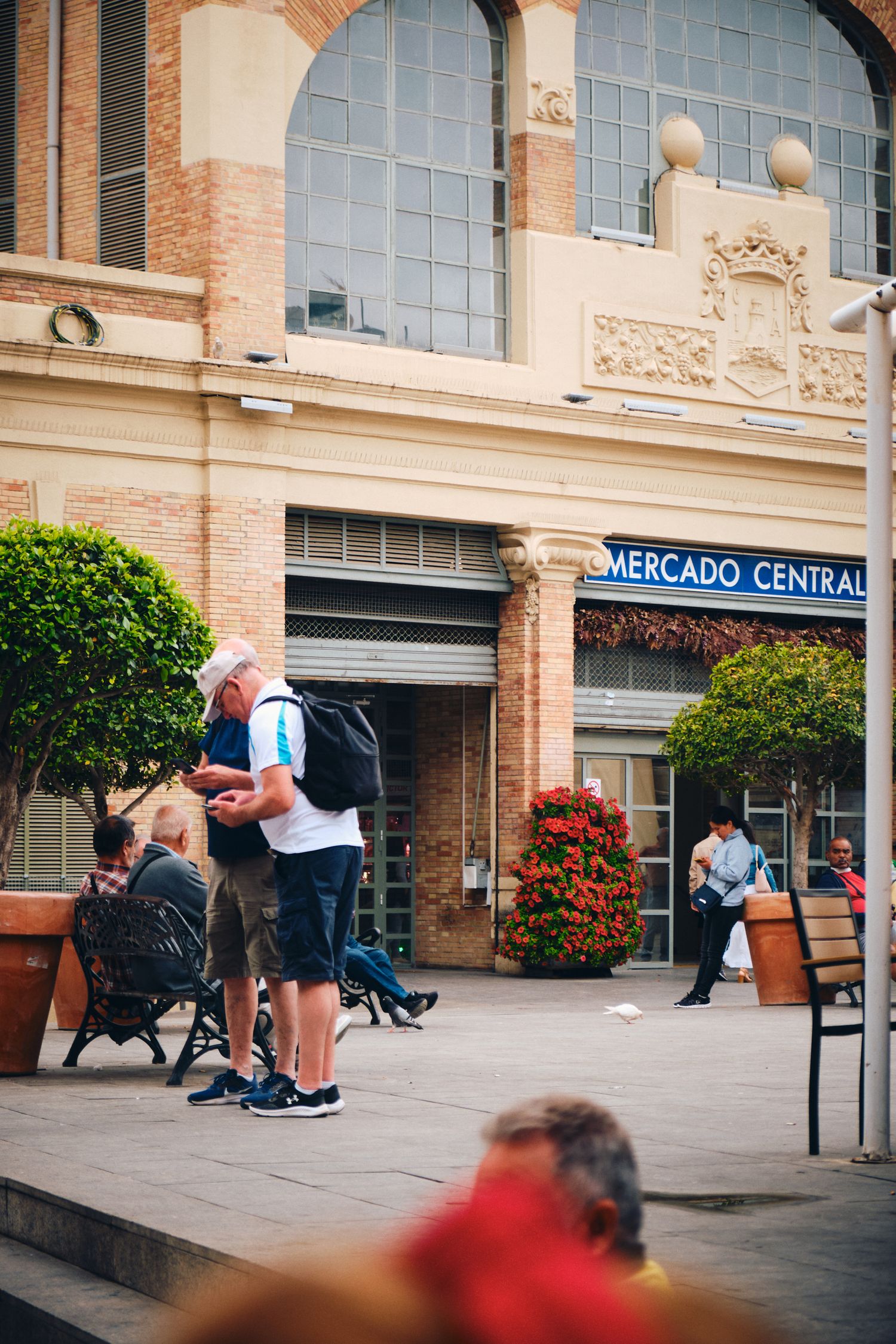 People gathering outside historic Mercado Central entrance with ornate architecture.