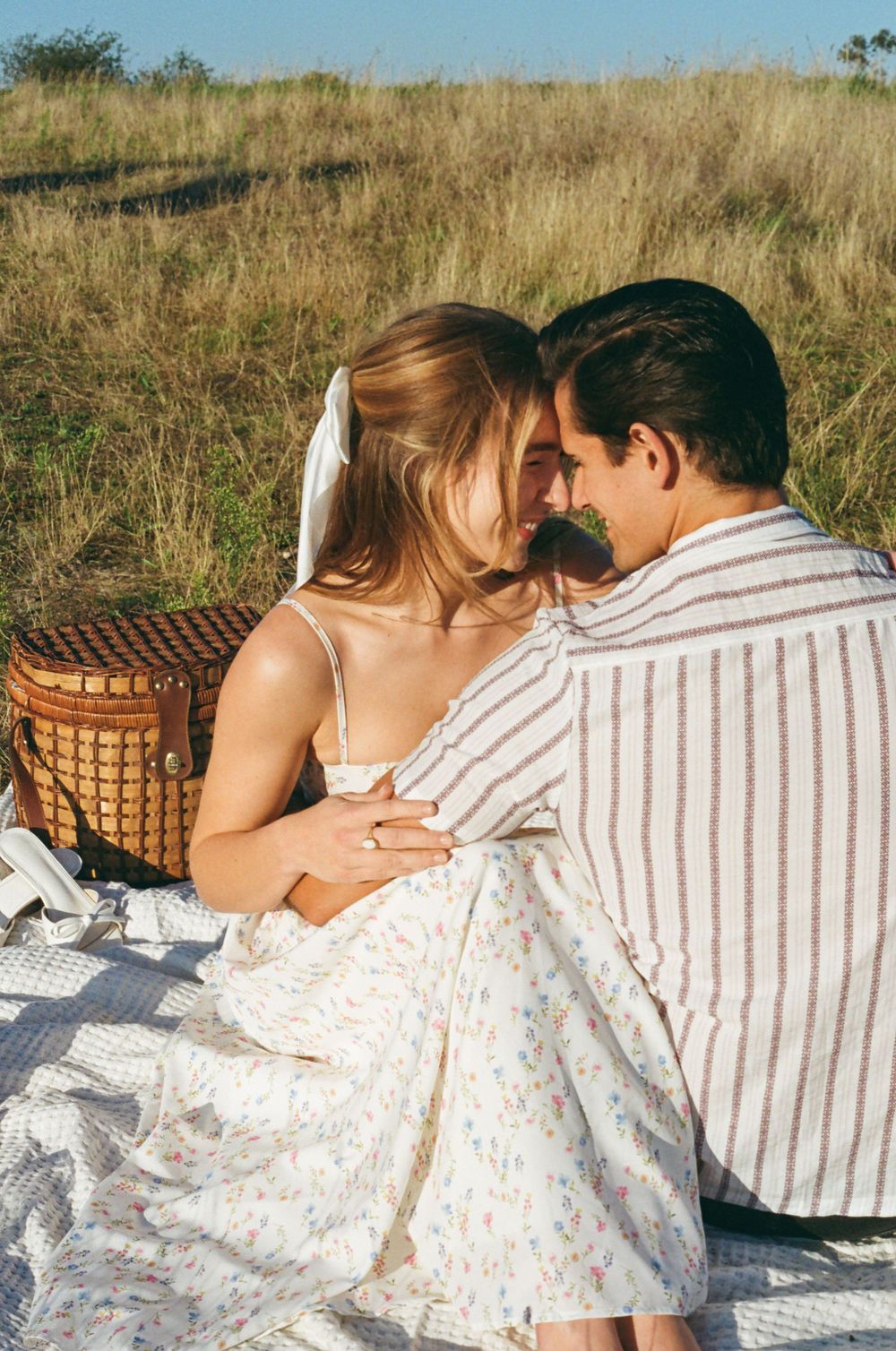 Intimate moment during sunset picnic with wicker basket.
