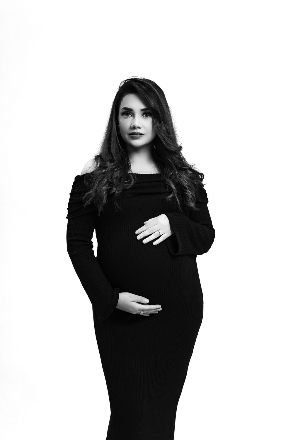 Classic black and white maternity portrait in a fitted long-sleeve dress.