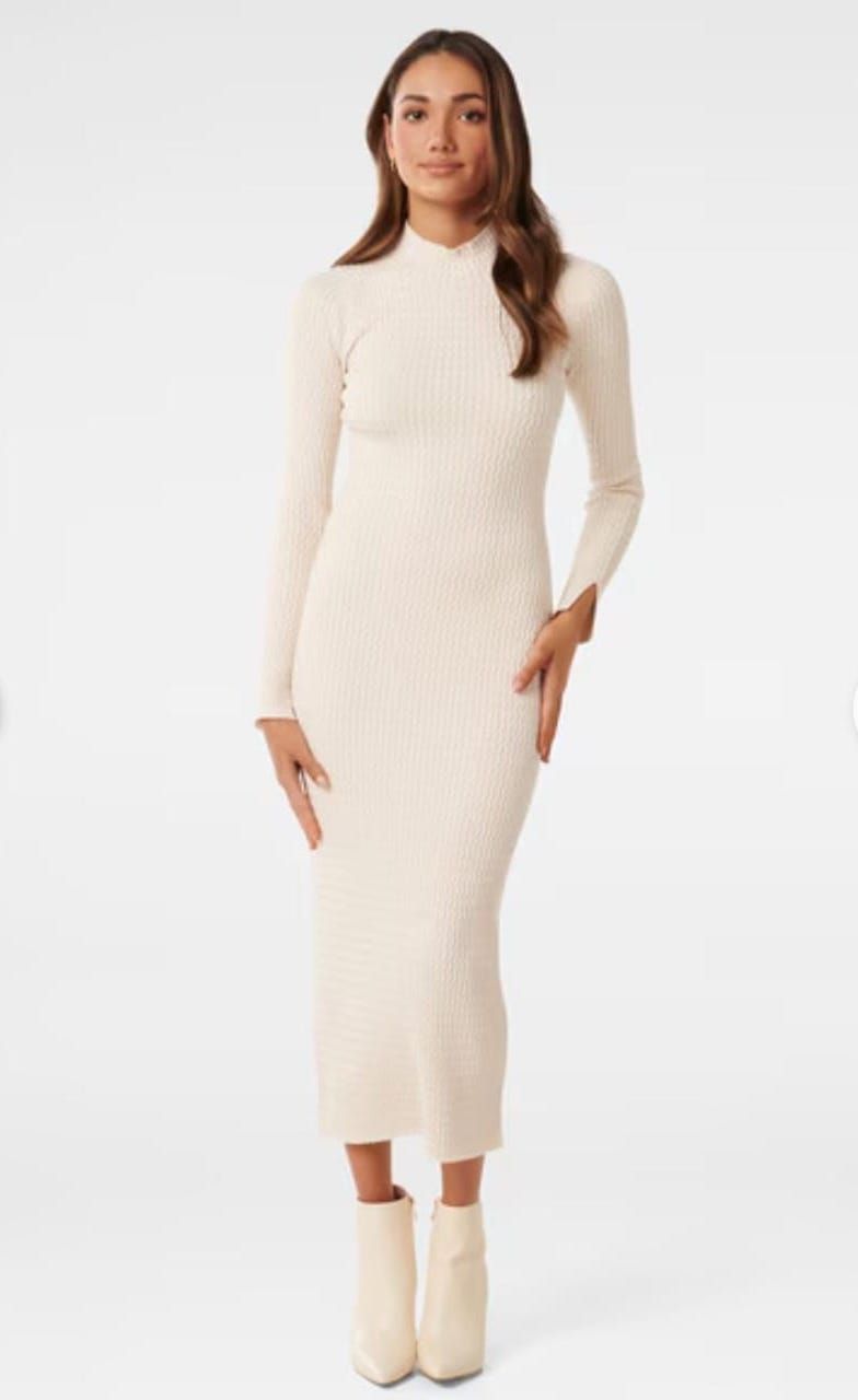 Long sleeve cream turtleneck dress styled with matching ankle boots.