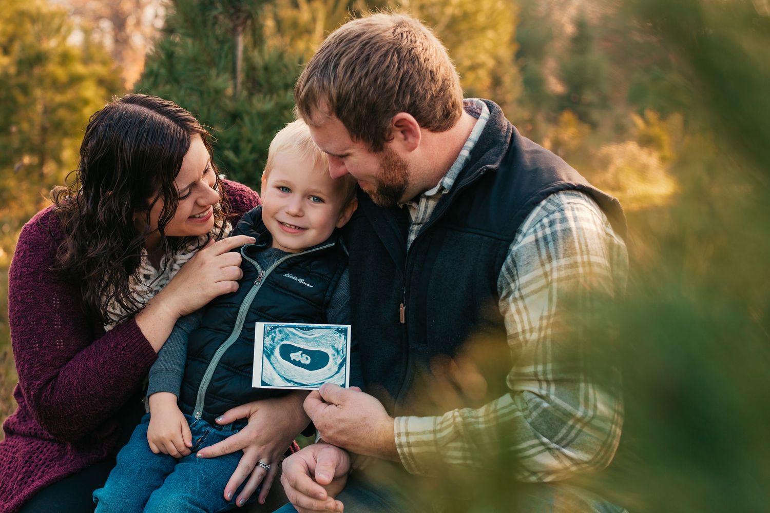 Family sharing intimate moment together outdoors during autumn photo session.