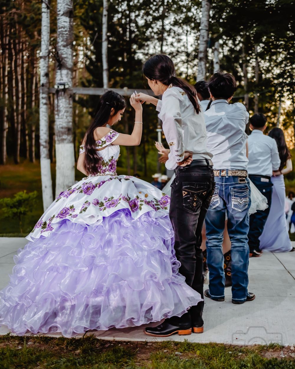 Purple ruffled quinceañera dress photographed during an outdoor sunset celebration. Quinceanera